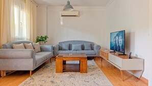 Una sala de estar moderna con un sofá, una mesa de centro, un televisor y un aparador.
