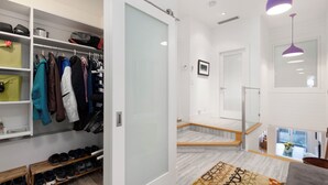 Een modern interieur met inloopkast, een trap en uitzicht op de bovenverdieping.