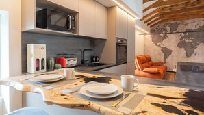 A modern kitchen with a wooden island, built-in appliances, and a world map wall. - 4 Elements - Italian GuestHouse (Calolziocorte)