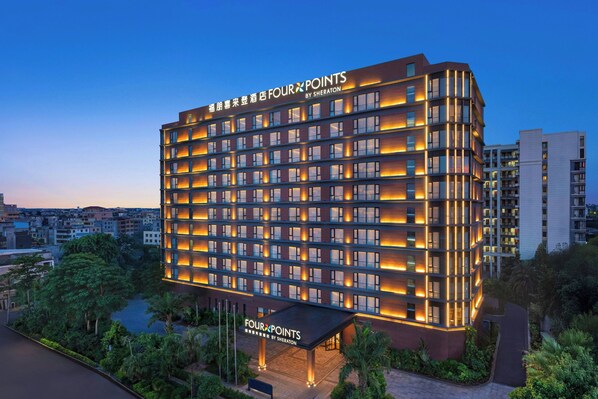 A multi-story hotel with a modern design, featuring a prominent signage and a covered entrance. - Four Points By Sheraton Haikou International Airport (Haikou)