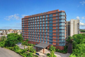 A multi-story hotel with a prominent 'Four Points' sign, a covered entrance, and a view of the surrounding urban area. - Four Points By Sheraton Haikou International Airport (Haikou)