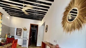Un comedor con un banco de madera, una mesa con sillas y un techo con vigas a la vista.