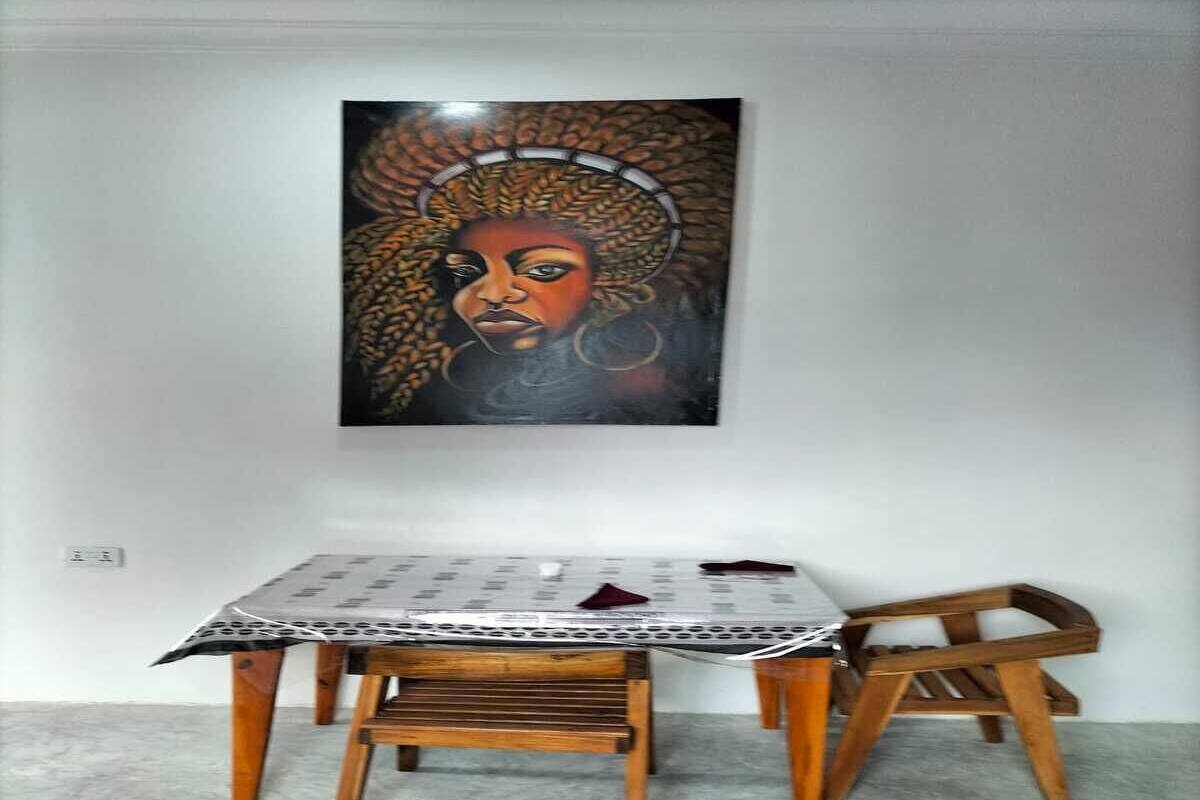 Un comedor con una mesa, sillas, un cuadro en la pared y un enchufe.