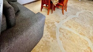 Un comedor con una mesa y sillas, un sofá y un techo con vigas a la vista.