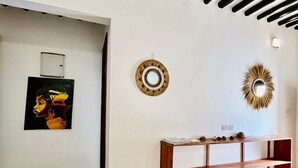 Una habitación con pared blanca, una consola de madera y un techo con vigas negras.