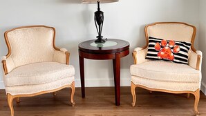 Deux fauteuils disposés de part et d’autre d’une table ronde, avec une lampe placée entre eux.