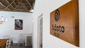 A wooden sign with the text "Ndoto HOUSE" mounted on a white wall. - Ndoto House in Rafiki Tamu Dunia Resort (Watamu)