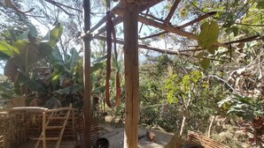 Un espace extérieur rustique doté d’une structure en bois, d’une échelle et d’un pneu.