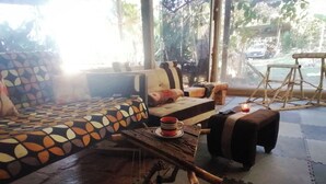 Une pièce chaleureuse avec un canapé à motifs, une table en bois sur laquelle se trouve une tasse, et un banc.