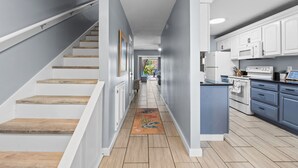 A modern kitchen with white cabinets, a built-in oven, and a microwave.