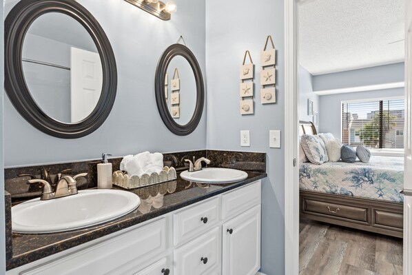 Un baño con dos lavamanos, un espejo grande y un mueble de tocador con cajones.