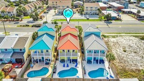 A beachfront hotel with multiple swimming pools, a beach view, and a location marker. - Fall Deals + Snowbird Rates | Coastal Stay Near the Beach (Panama City)