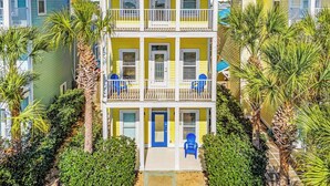 A multi-story building with a red roof, white balconies, and a blue door. - Fall Deals + Snowbird Rates | Coastal Stay Near the Beach (Panama City)