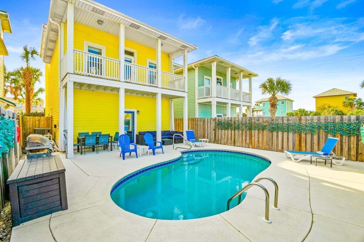 Un espace piscine comprenant une piscine, des chaises longues et une terrasse en bois.
