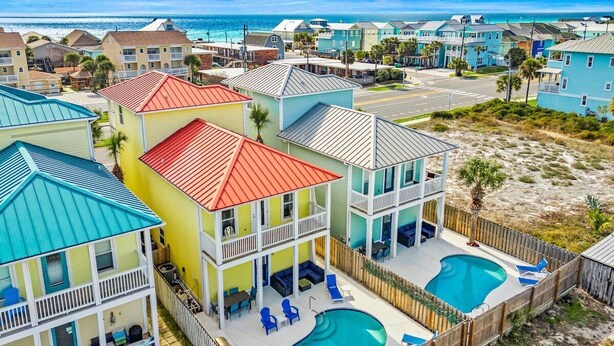 A coastal residential area with multiple two-story houses featuring balconies, a swimming pool, and a beach view. - Fall Deals + Snowbird Rates | Coastal Stay Near the Beach (Panama City)