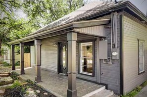 A single-story house with a covered porch, a front door, and a small window. - The Wander Inn: 2 Bed-2 Bath Bungalow Recently Renovated, Walk to Downtown (Weatherford)