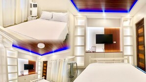 A hotel room with a bed, a TV, a desk, and a shower area. - Affordable Transient Room in Lipa City Near SM and LIMA (Lipa City)