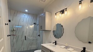 Un baño moderno con dos lavamanos, inodoro y ducha.