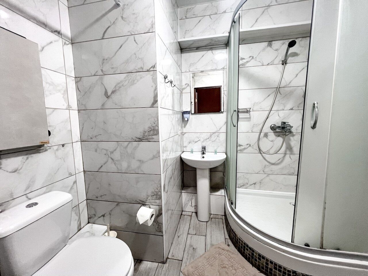 Un baño con inodoro, lavamanos y ducha.