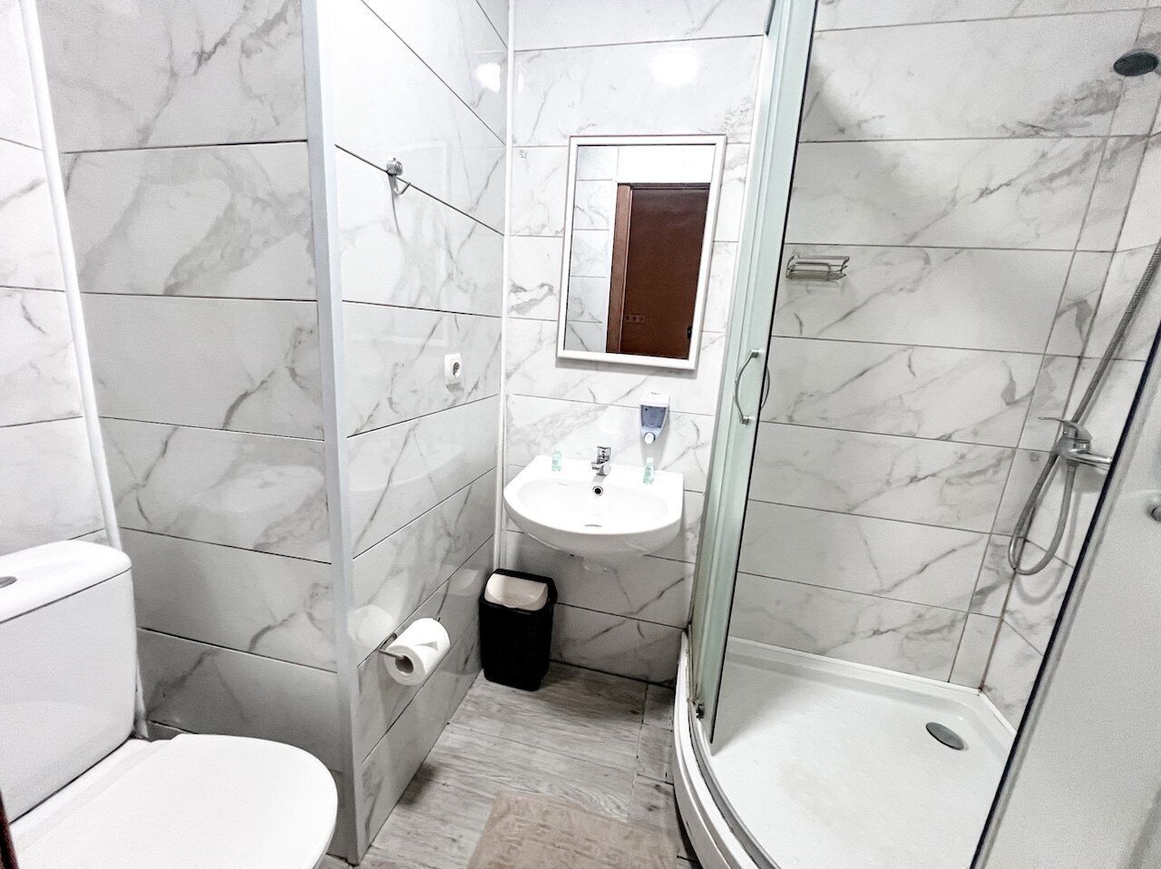 A bathroom with a toilet, sink, and shower.