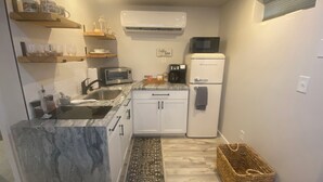 A compact kitchen with a sink, a toaster, a coffee maker, and a refrigerator. - Peaceful Pines Haven~ cozy studio near the ponds (Hanson)