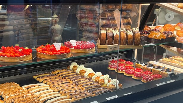 Una vitrina de pastelería con diversos pasteles y postres.