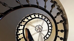 Una escalera de caracol con barandillas ornamentales y una barandilla central.