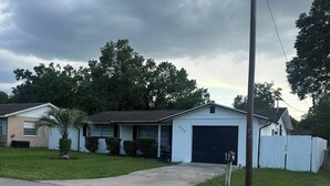 A residential house with a garage, a front lawn, and a mailbox.