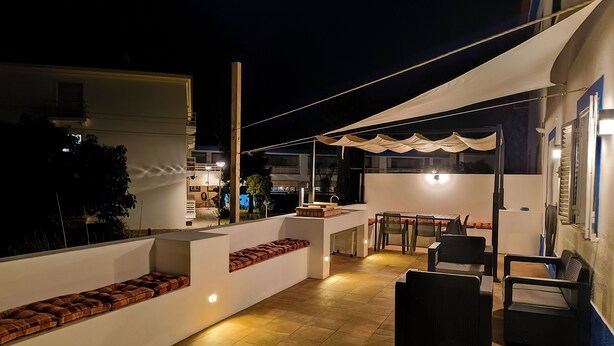 Eine Dachterrasse mit Essbereich, Sitzgelegenheiten und einer kleinen Küche.