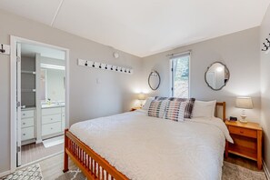 A bedroom with a bed, bedside tables, a mirror, a coat rack, and a wardrobe. - Bridges 77 at Sugarbush (Warren)