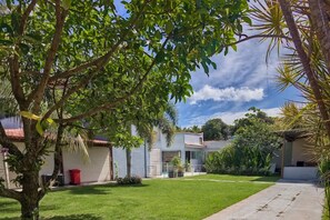 Un barrio residencial con un césped cuidado, un sendero y una casa de techo con tejas.