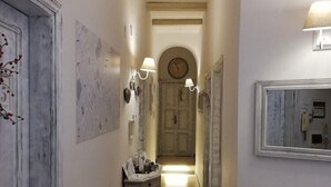 Un pasillo estrecho con suelo de baldosas, un armario de madera y un radiador en la pared derecha.