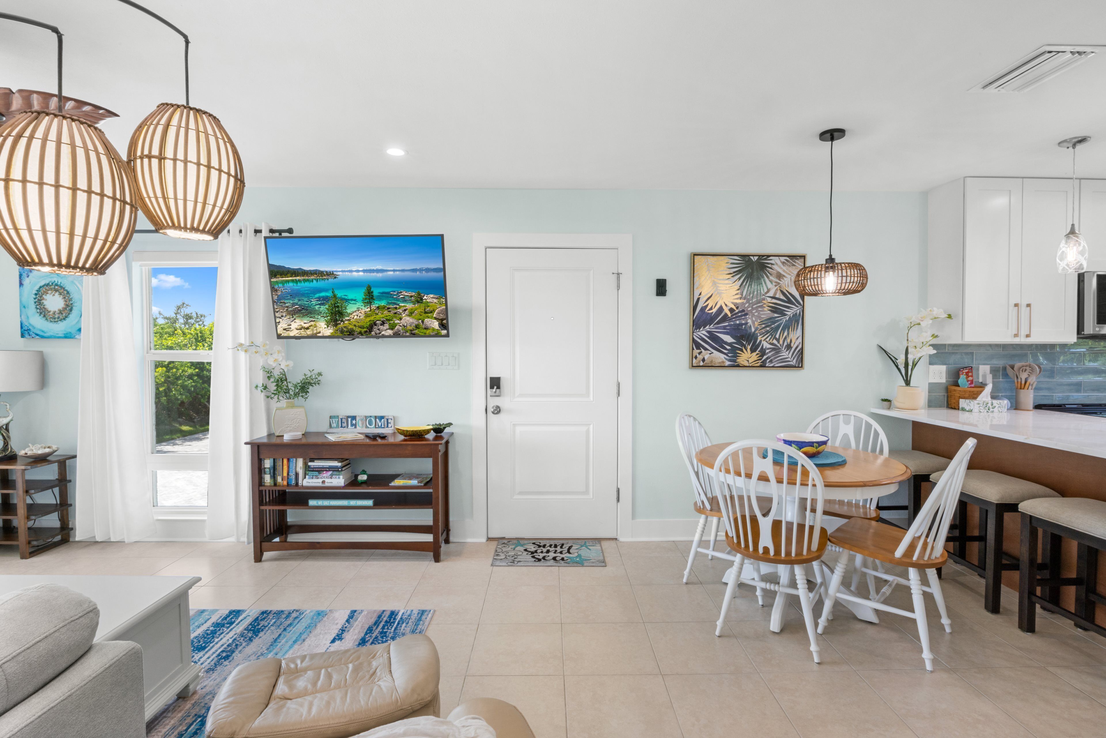 A modern living room with a sofa, a dining table with chairs, and a kitchen area with cabinets and a countertop.
