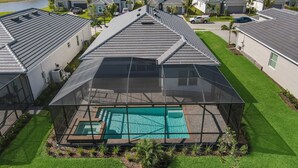 Zona residencial con casas de techo inclinado y una piscina con cerramiento de vidrio.