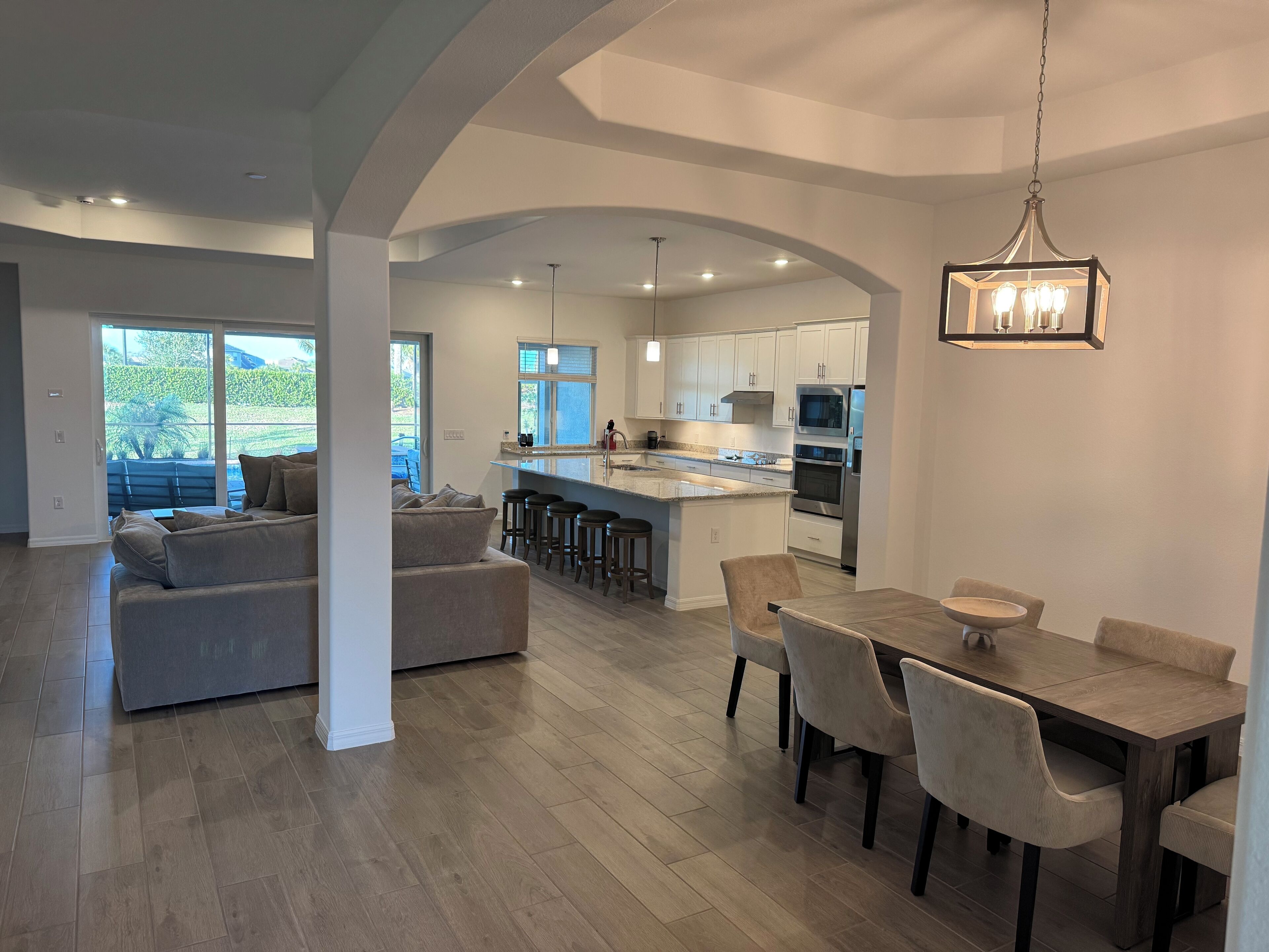 Una cocina amplia con una isla central, electrodomésticos modernos y una zona de comedor con mesa y sillas.