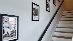 Un escalier muni d’une rampe et un mur orné de souvenirs de sport encadrés.