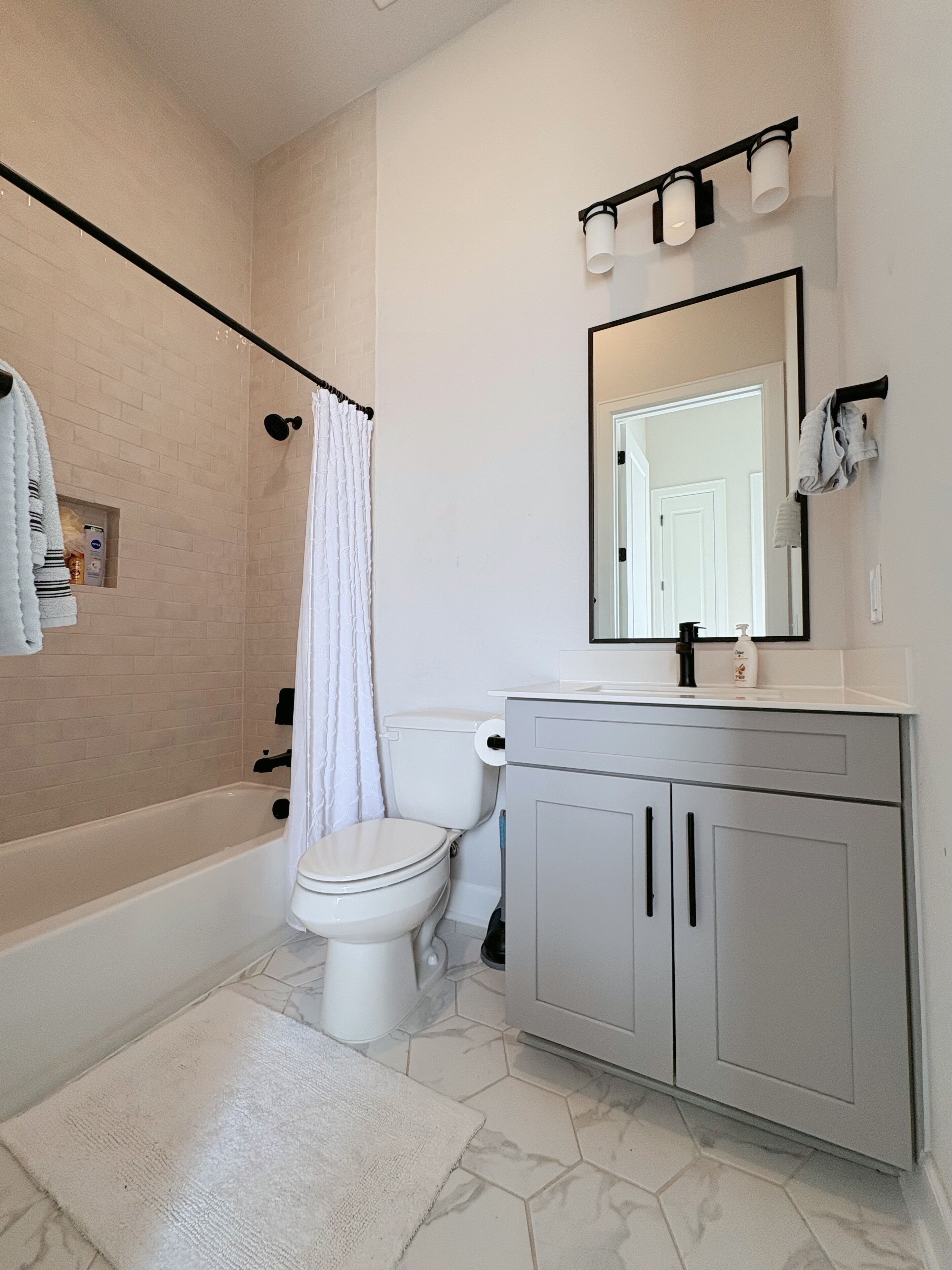 A modern bathroom with a bathtub, toilet, and vanity.