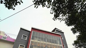 A building with a large glass facade and the sign "OM PALACE" above the entrance. - Hotel Om Palace (Vrindavan)