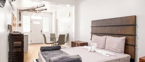 A bedroom with a bed, a wooden headboard, a desk, and a chair.