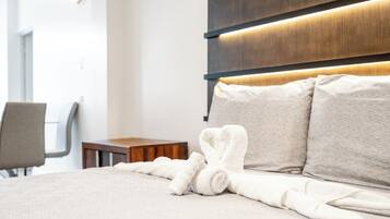 Une chambre d’hôtel avec un lit bien fait, une table de chevet en bois et une chaise.