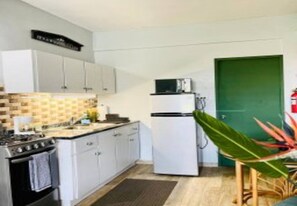 Standaard appartement | Privékeuken | Een koelkast, kookgerei, borden en bestek