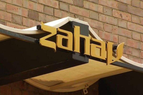 Un letrero con la palabra "Zahav" en letras amarillas estilizadas.