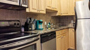 A kitchen with a stove, microwave, coffee maker, and dishwasher.