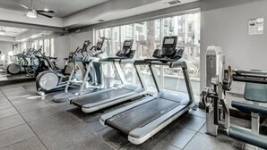 A gym with treadmills, stationary bikes, and a rowing machine.