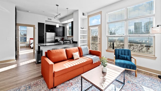 A modern apartment with a kitchen, living room, and large windows.