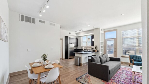 A modern apartment with a dining area, kitchen, living room, and large windows. - Stylish 1Br in Deep Ellum with Free Parking Near Baylor Med (Dallas)