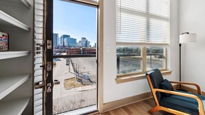 A room with a large window, a chair, and a floor lamp. - Stylish 1Br in Deep Ellum with Free Parking Near Baylor Med (Dallas)
