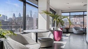 A modern interior with a city view, a round table, and seating areas.