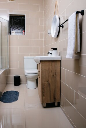 A modern bathroom with a toilet, sink, and mirror.