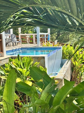 Una piscina al aire libre, sillones reclinables de piscina